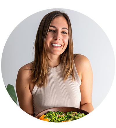 Sarah Cobacho, plant-based nutritionist profile photo holding a vibrant salad whilst smiling